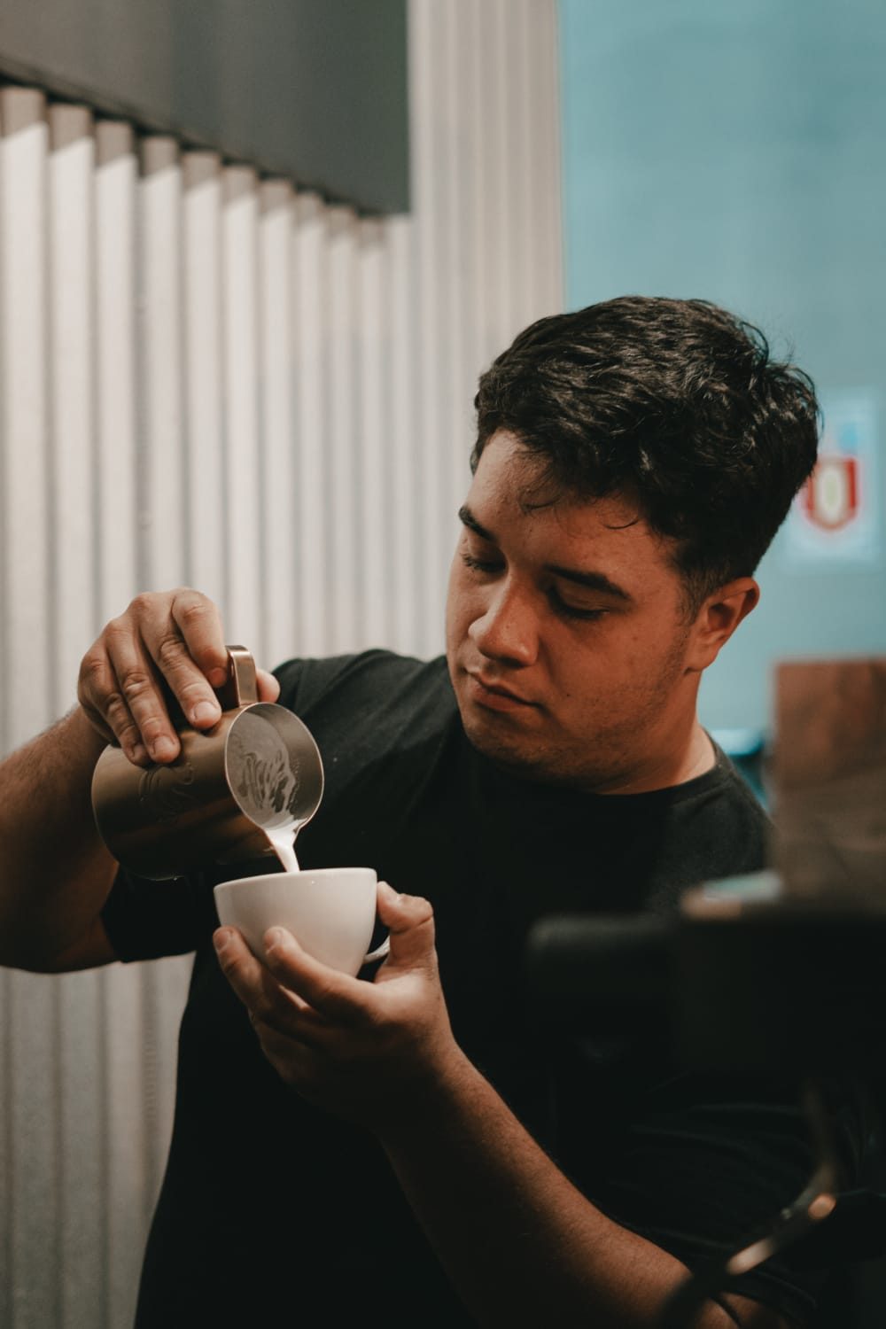 Barista despejando leite vaporizado na xícara